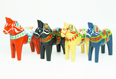 A row of hand-painted Dala horses in red, blue, white and black, each decorated with kurbits flower patterns